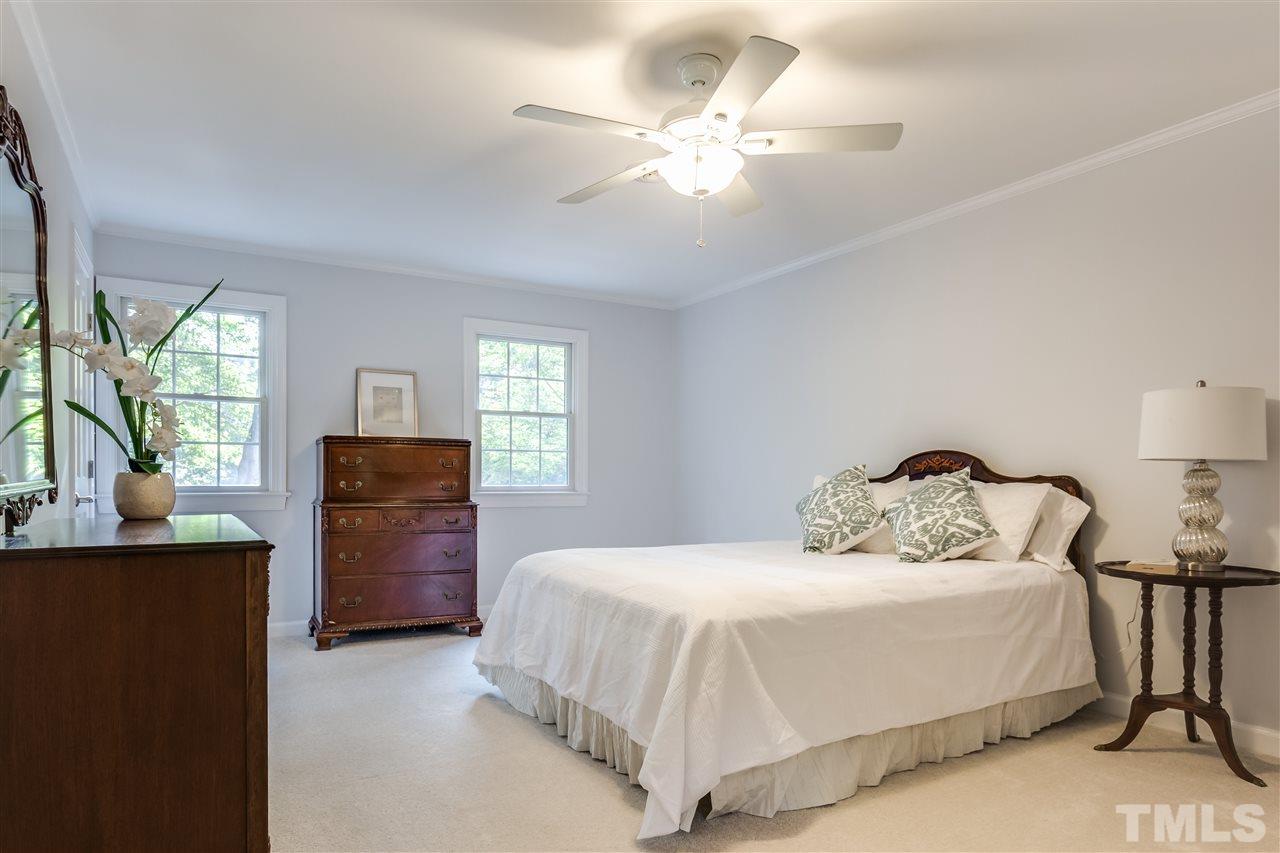 8713 Cliff Top Court Raleigh, NC 27613 - Photo 16 of 25 a bedroom with a bed and a chandelier