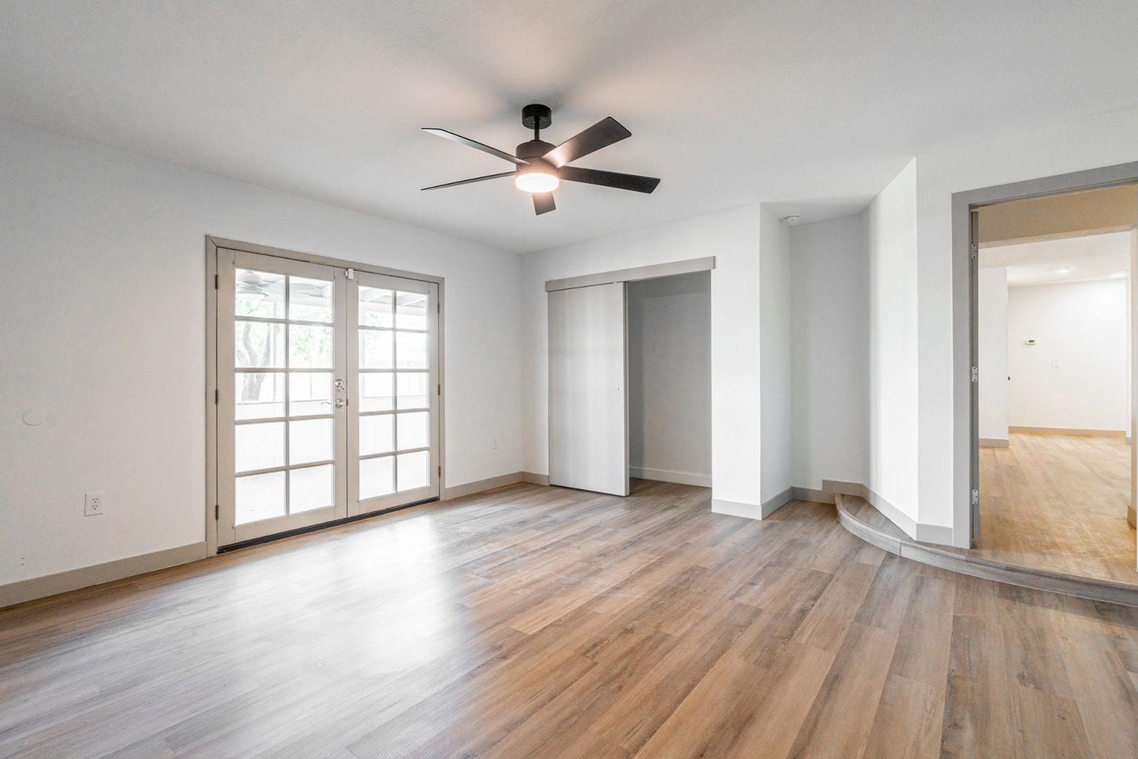 5739 West Monte Vista Road Phoenix, AZ 85035 - Photo 10 of 23 an empty room with wooden floor chandelier fan and windows