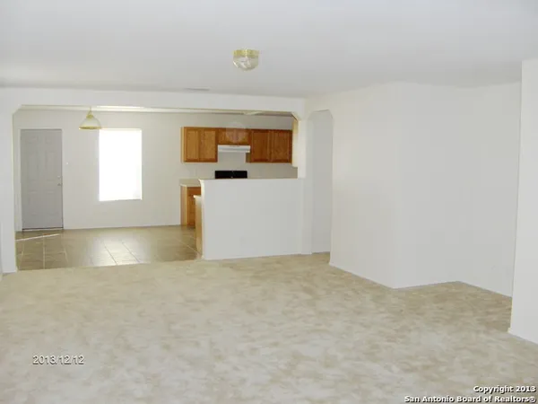 a kitchen with granite countertop a sink a stove top oven and cabinetry