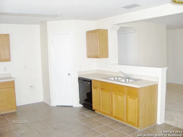 a utility room with a sink a stove and a refrigerator