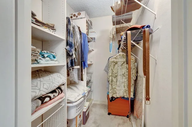 a view of walk in closet with clothes and shoes