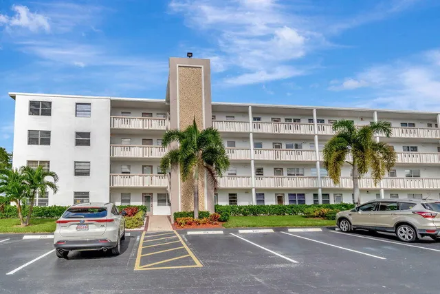 a car parked in front of a building with palm trees