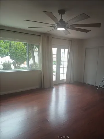 an empty room with wooden floor and windows