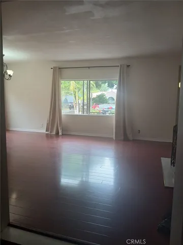 a view of room with window and wooden floor