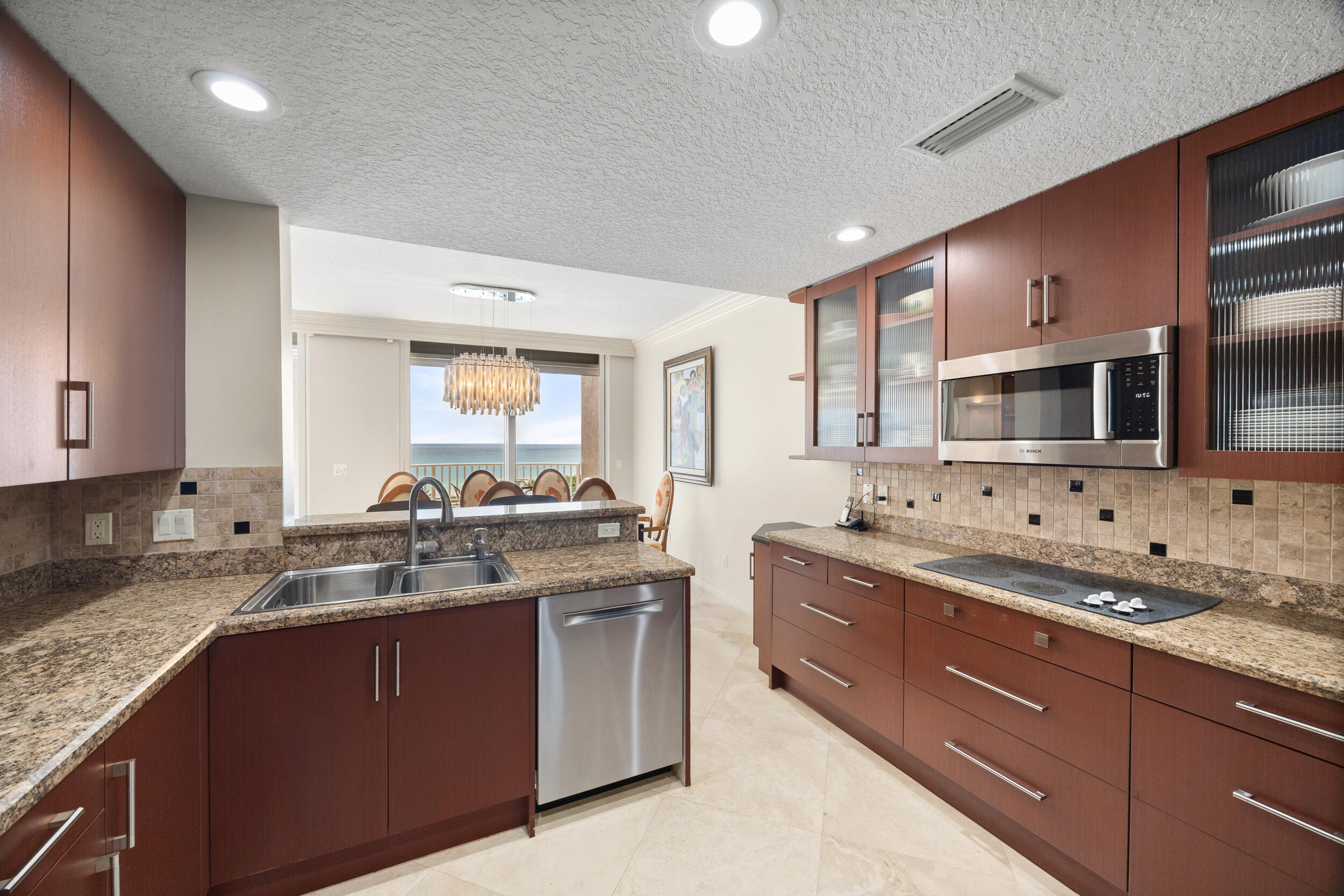 700 Ocean Royale, Unit 601 Juno Beach, FL 33408 - Photo 11 of 56 a kitchen with stainless steel appliances granite countertop a sink stove and microwave