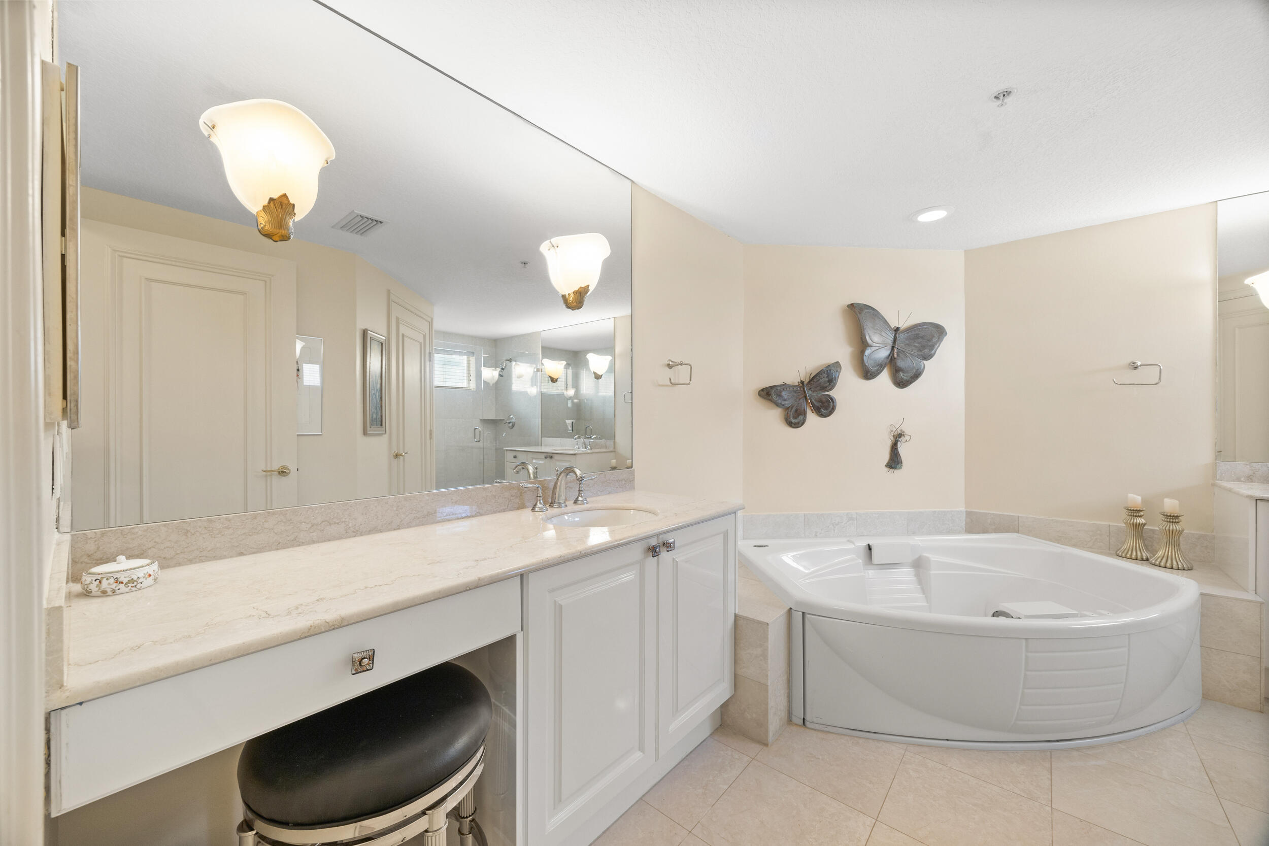 700 Ocean Royale, Unit 601 Juno Beach, FL 33408 - Photo 25 of 56 a bathroom with a bathtub a sink and a large mirror