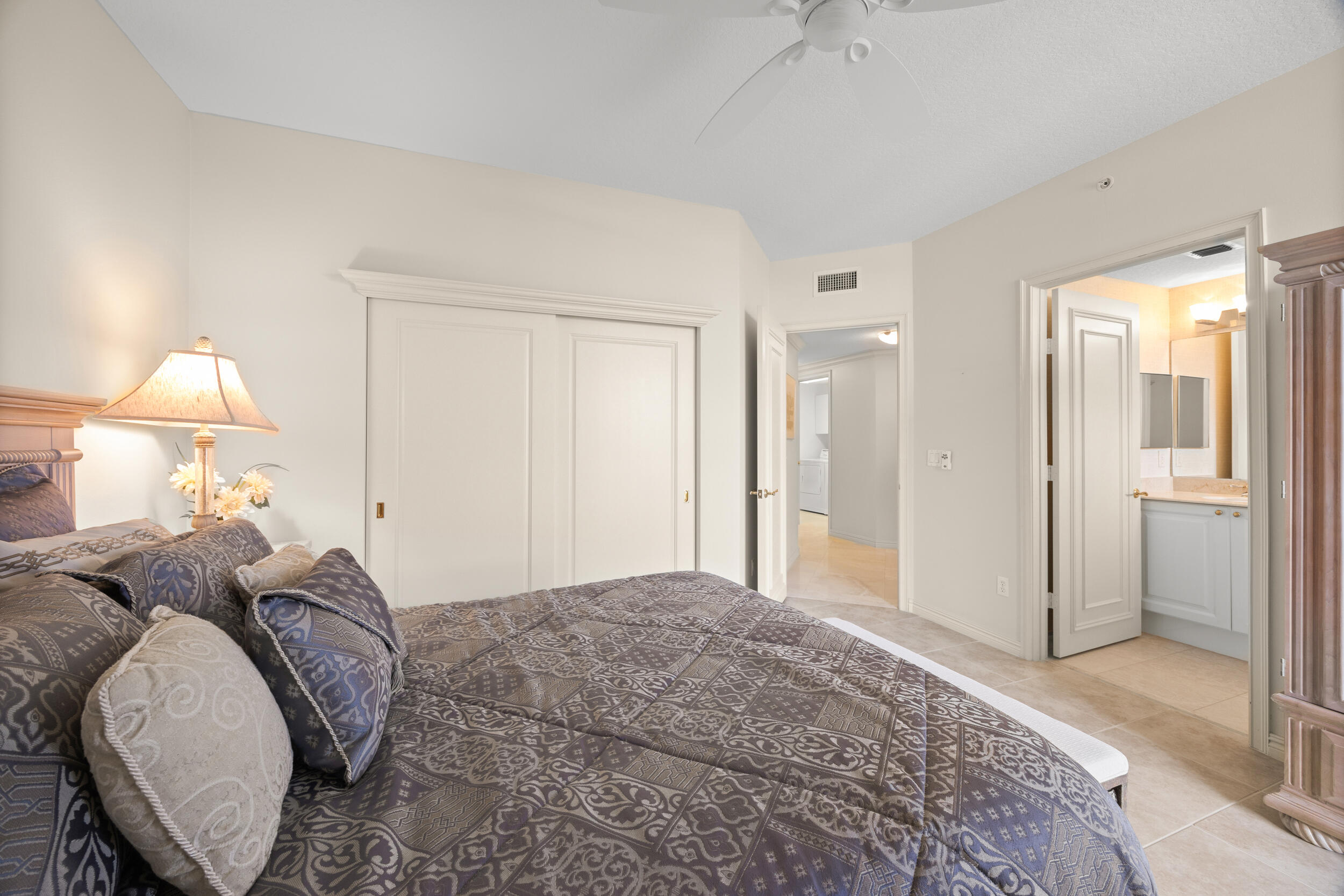 700 Ocean Royale, Unit 601 Juno Beach, FL 33408 - Photo 30 of 56 a spacious bedroom with a bed and a lamp