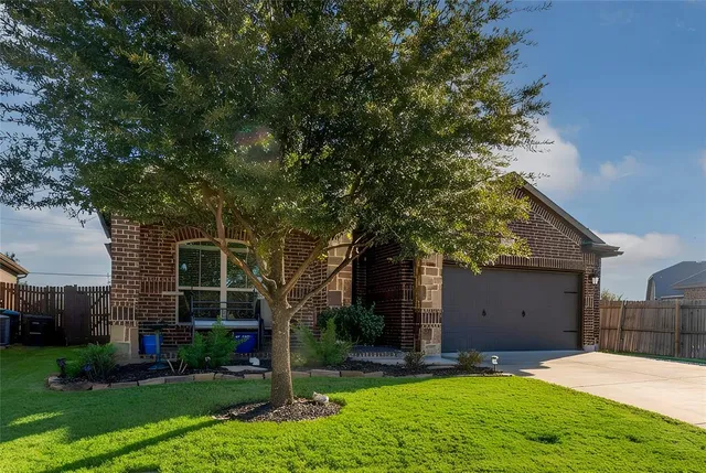 front view of a house with a yard and an trees