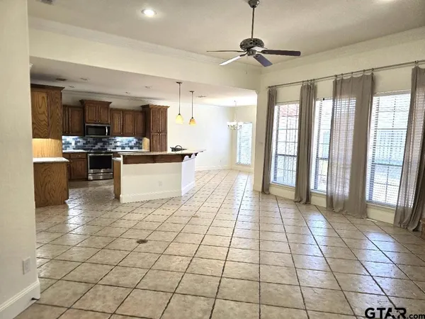 a view of a kitchen with kitchen island granite countertop a large counter top space appliances and cabinets