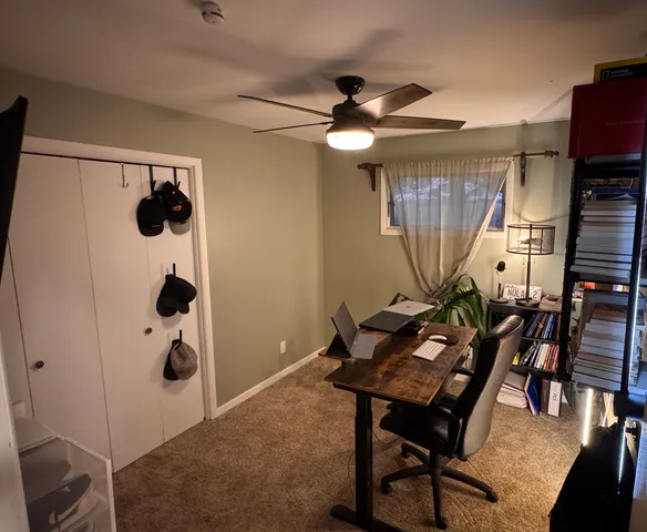 a view of a workspace with furniture and a fan