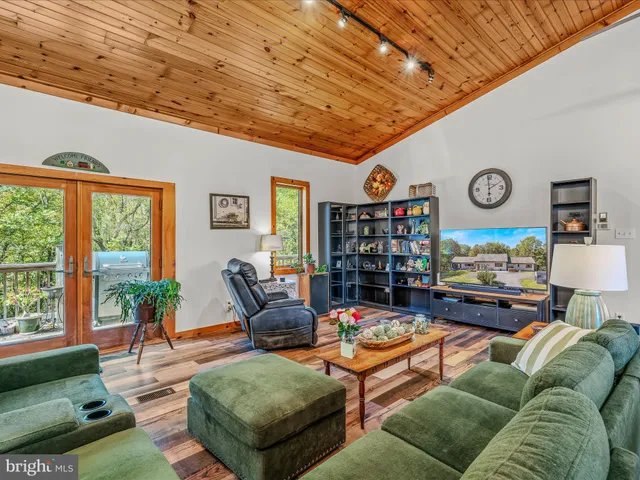 a living room with furniture kitchen view and a large window