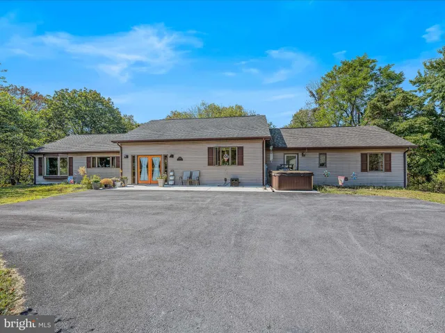 a front view of a house with large windows and a table and chairs