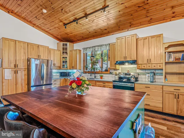 a kitchen with stainless steel appliances granite countertop a stove refrigerator sink and cabinets