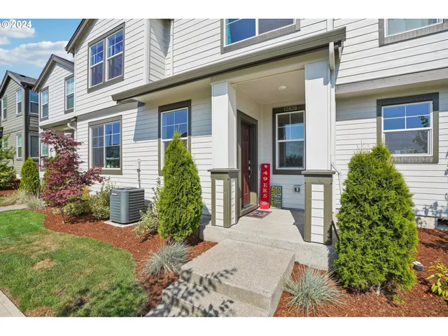 a view of a house with potted plants and a table and chairs