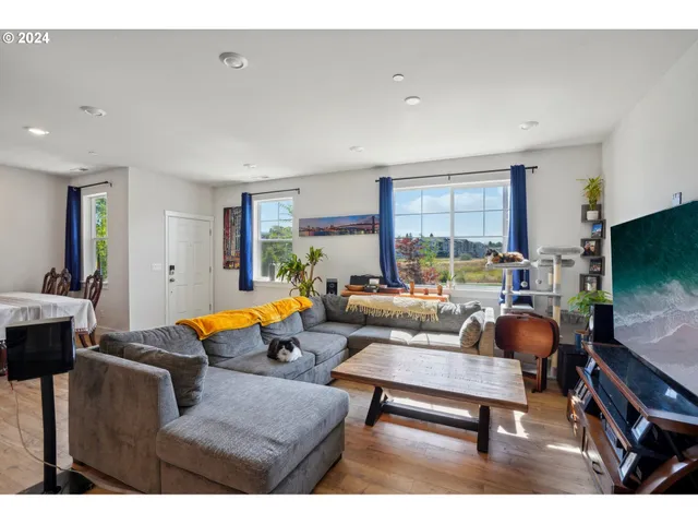 a living room with furniture a flat screen tv and a table