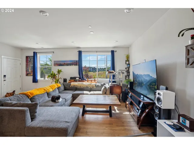 a living room with furniture a rug a flat screen tv and a window