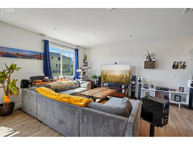a living room with furniture a flat screen tv and a large window