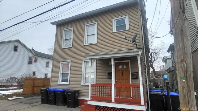 a view of a house with a barbeque and wooden fence