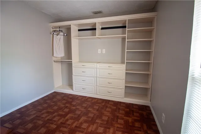 a view of walk in closet with empty racks