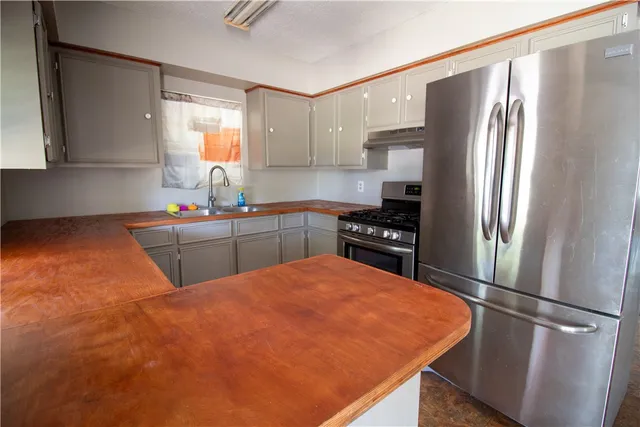 a kitchen with stainless steel appliances a refrigerator sink and cabinets