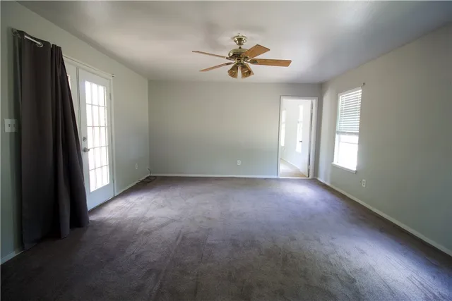 a view of a livingroom with a ceiling fan and window