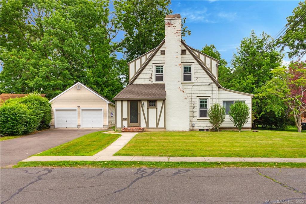 a view of a house with a yard and large trees