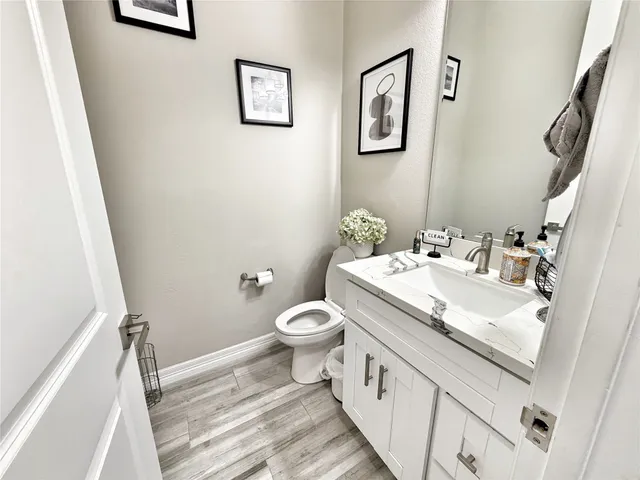 a bathroom with a granite countertop sink toilet and a mirror