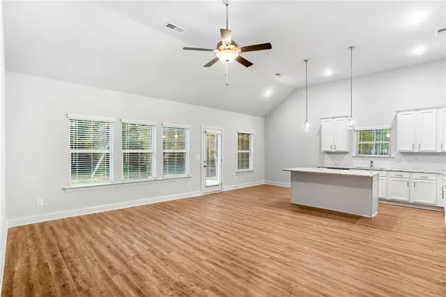 a large kitchen with cabinets wooden floor and stainless steel appliances
