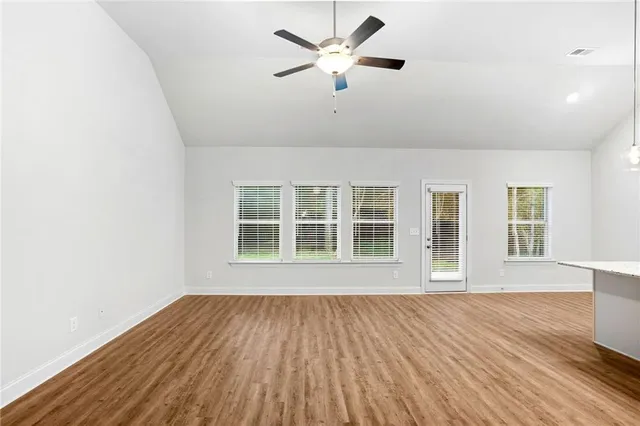 a large kitchen with cabinets wooden floor and stainless steel appliances