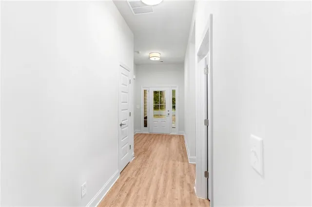 a view of a hallway with wooden floor