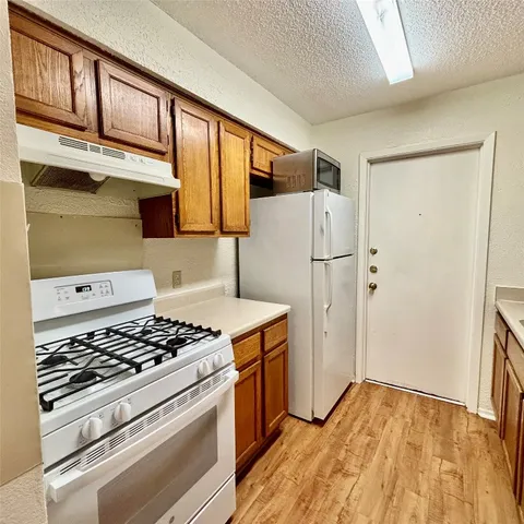 a kitchen with a stove a refrigerator and a cabinets