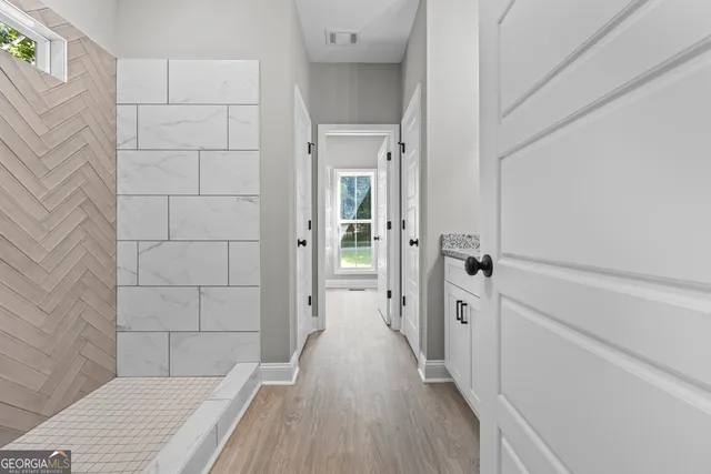 a view of a bathroom with a sink and wooden floor