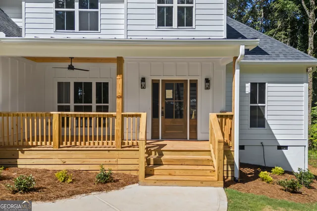 a view of a house with a small yard and wooden floor and fence