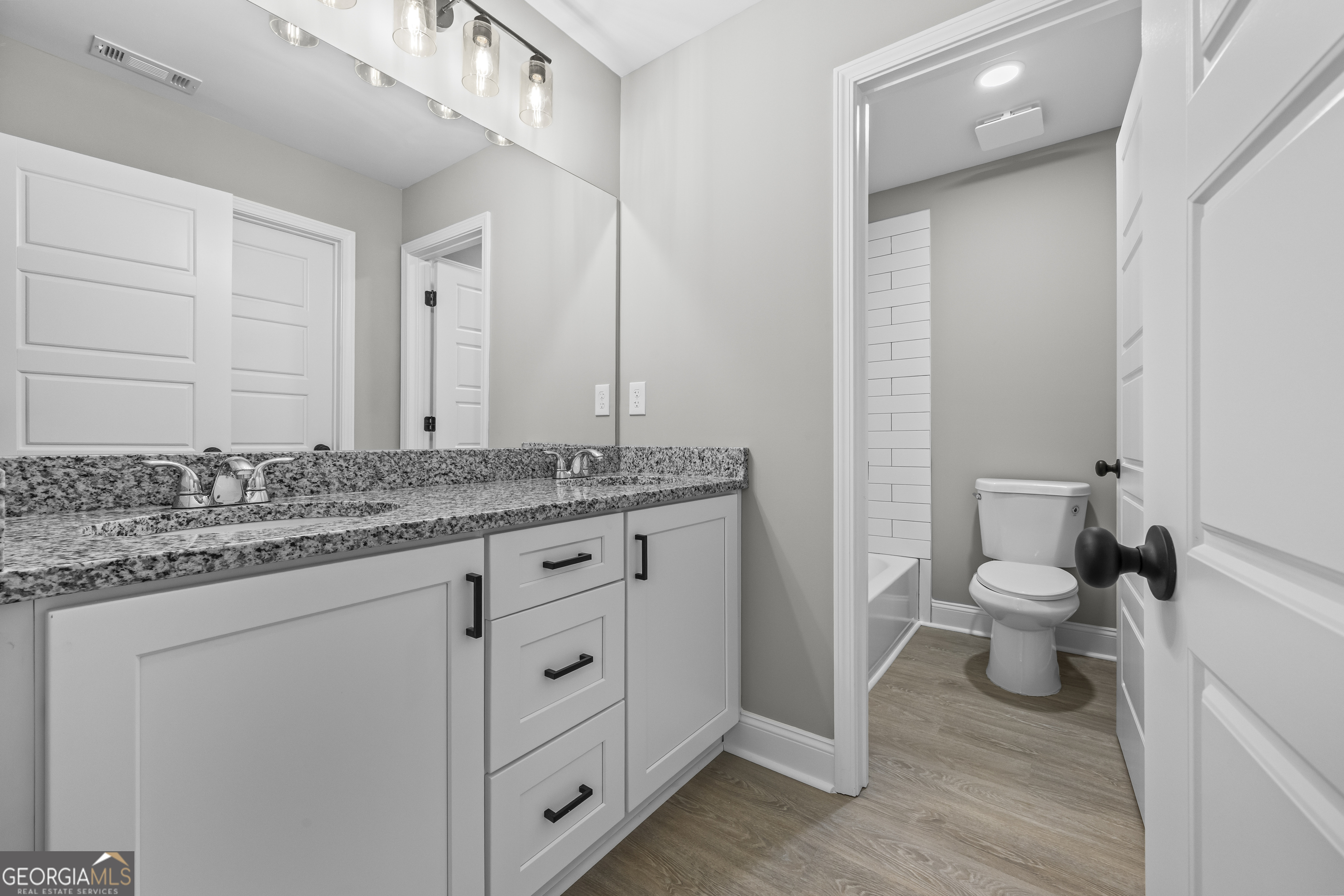119 Gordon Road Commerce, GA 30530 - Photo 25 of 40 a bathroom with a granite countertop toilet sink and mirror