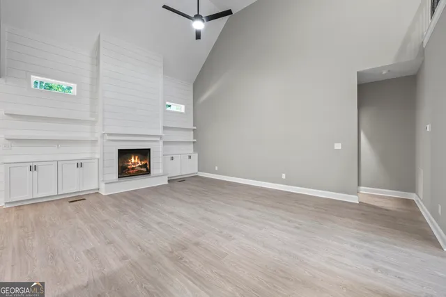 a view of an empty room with a fireplace and a window