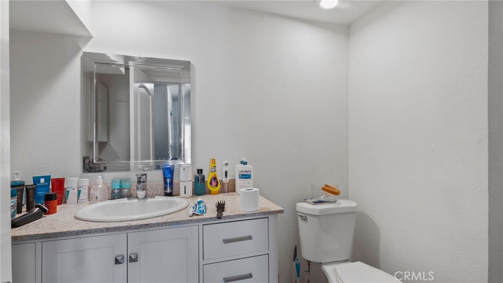 8035 Santa Rita Street Corona, CA 92881 - Photo 22 of 37 a bathroom with a sink toilet vanity and a window