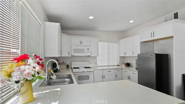 a kitchen with white cabinets and refrigerator