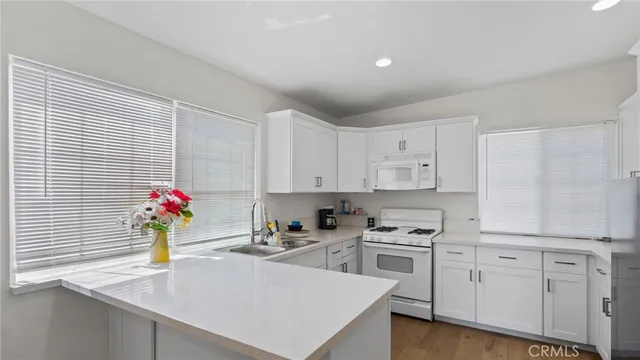 a kitchen with white cabinets and white appliances