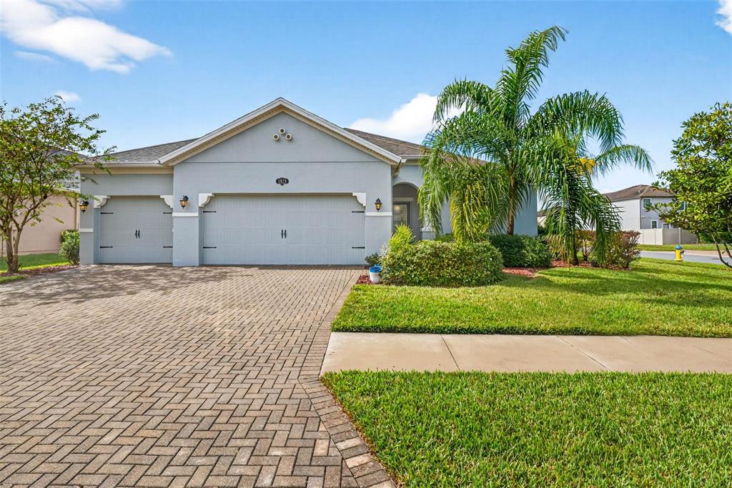 a view of a white house with a yard and potted plants