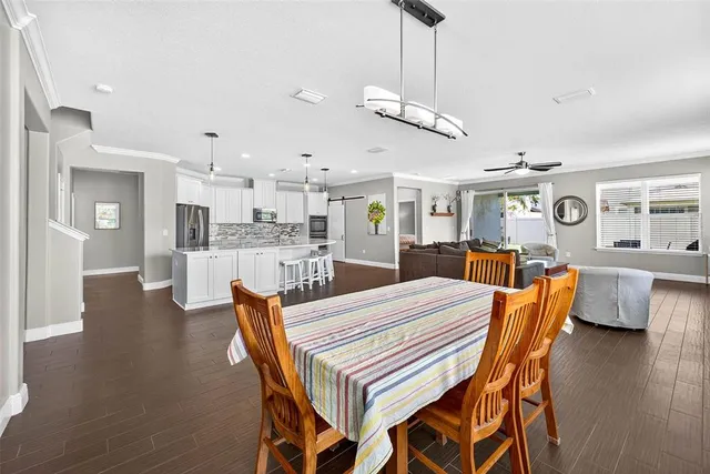 a kitchen with refrigerator and chairs