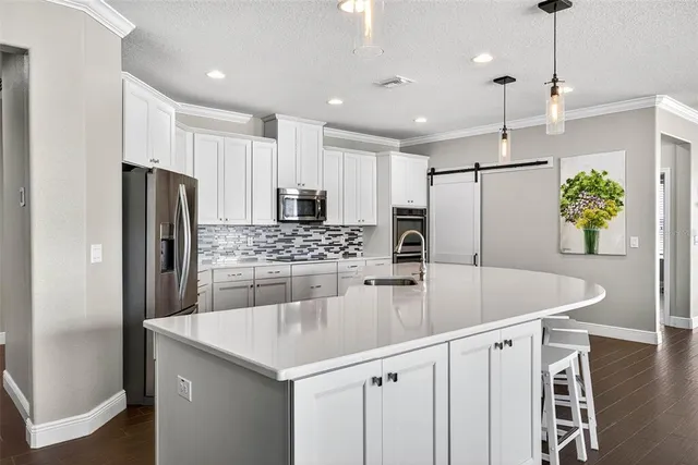 a kitchen with stainless steel appliances a sink stove and refrigerator