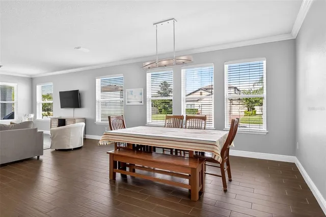 a kitchen with stainless steel appliances granite countertop a sink a refrigerator a counter and chairs