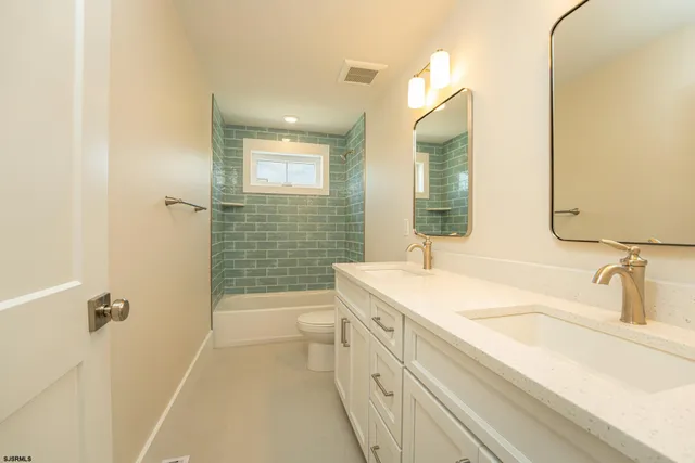 a bathroom with a sink a toilet a mirror and shower