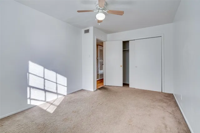 an empty room with windows and closet