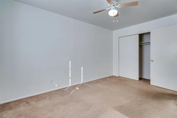 a view of an empty room with a ceiling fan