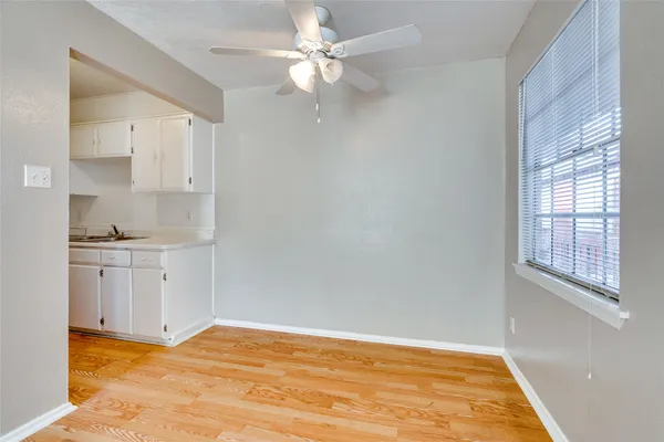 a view of an empty room with window and cabinet