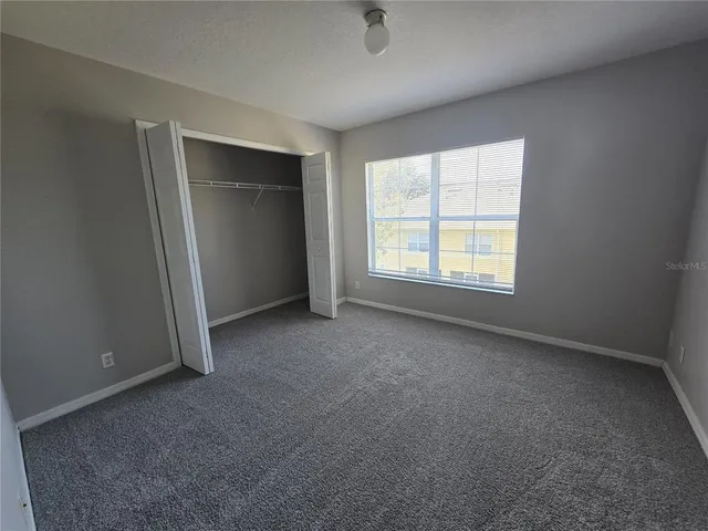 an empty room with windows and closet