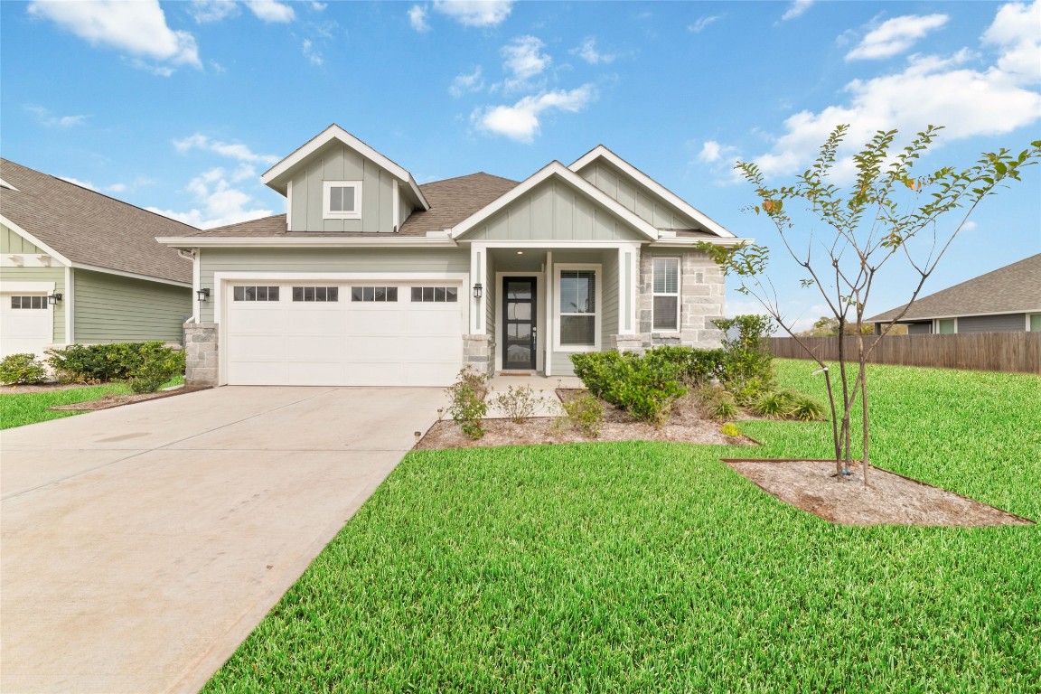 a front view of a house with a yard and trees