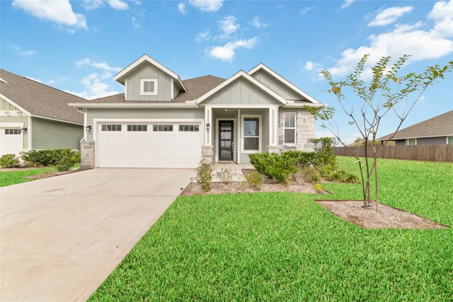 a front view of a house with a yard and trees