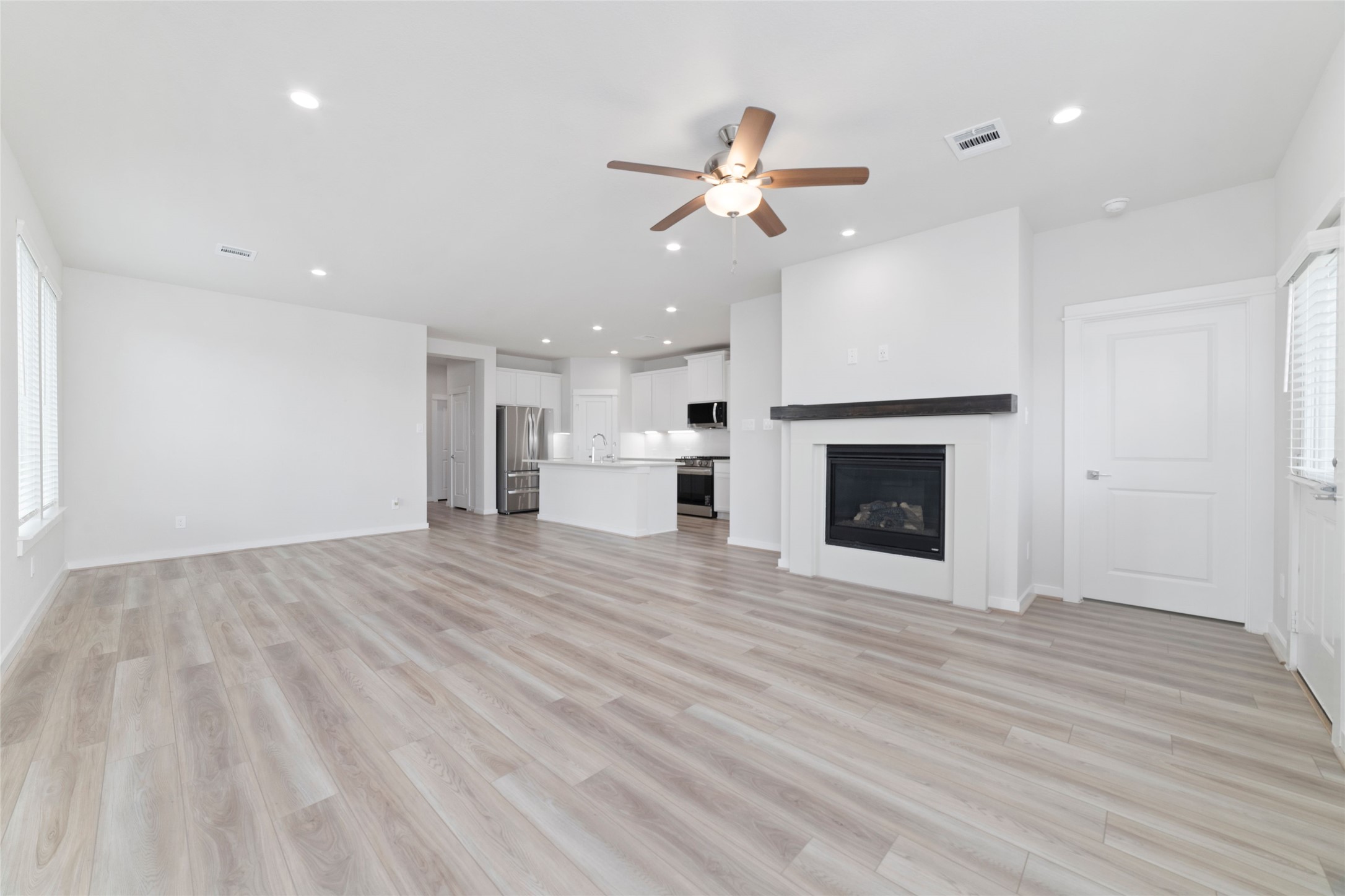 32906 School Hl Road Fulshear, TX 77441 - Photo 14 of 25 a view of an empty room with wooden floor fireplace and a window